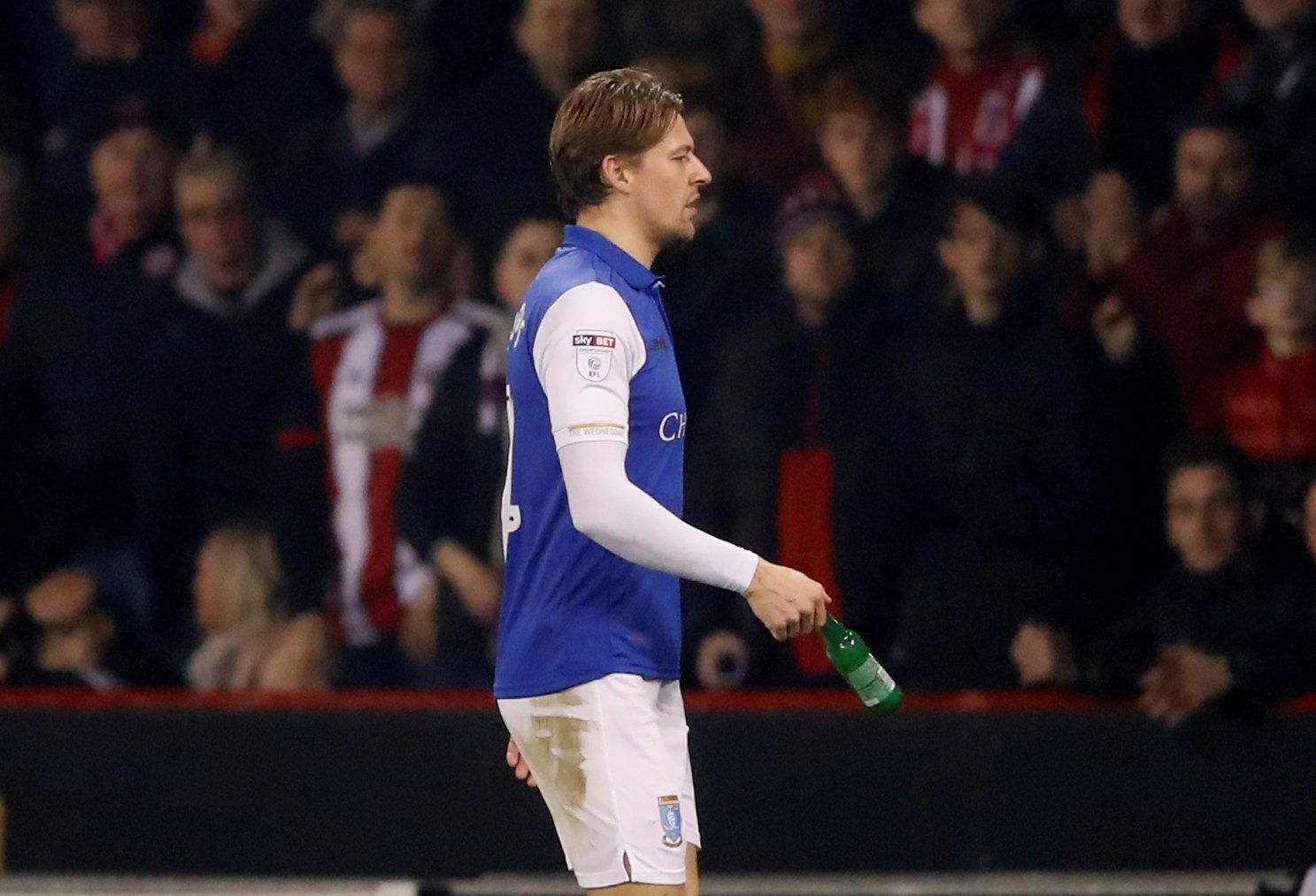 Soccer Football - Championship - Sheffield United vs Sheffield Wednesday - Bramall Lane, Sheffield, Britain - January 12, 2018   Sheffield Wednesday's Glenn Loovens holds a bottle that was thrown onto the pitch after being sent off         Action Images/Carl Recine    EDITORIAL USE ONLY. No use with unauthorized audio, video, data, fixture lists, club/league logos or "live" services. Online in-match use limited to 75 images, no video emulation. No use in betting, games or single club/league/play