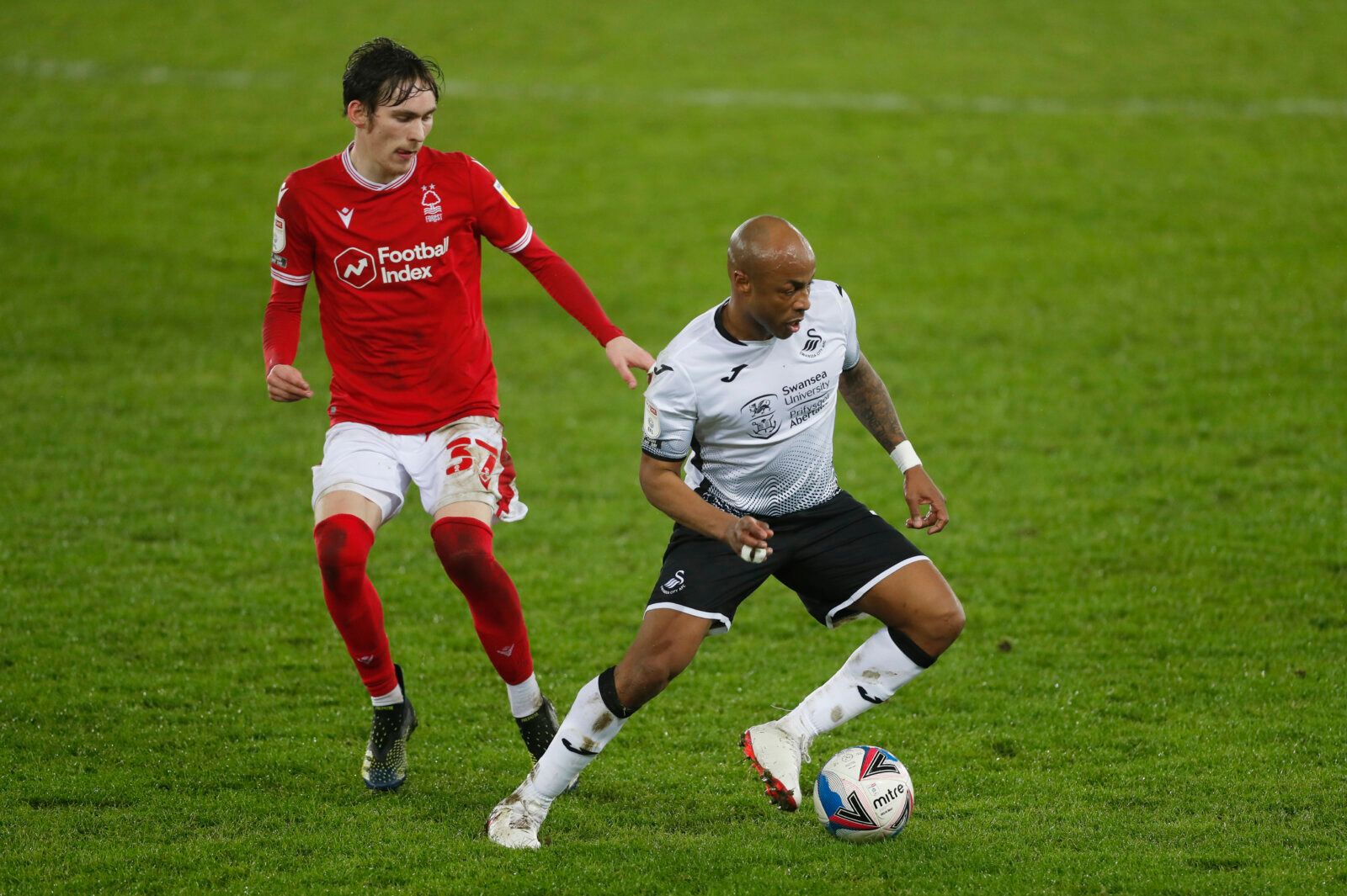 Soccer Football - Championship - Swansea City v Nottingham Forest - Liberty Stadium, Swansea, Wales, Britain - February 17, 2021 Swansea City's Andre Ayew in action with Nottingham Forest's James Garner Action Images/Matthew Childs EDITORIAL USE ONLY. No use with unauthorized audio, video, data, fixture lists, club/league logos or 'live' services. Online in-match use limited to 75 images, no video emulation. No use in betting, games or single club /league/player publications.  Please contact you