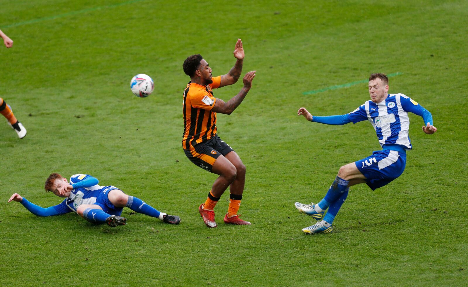 Soccer Football - League One - Hull City v Wigan Athletic - KCOM Stadium, Hull, Britain - May 1, 2021 Hull City's Malik Wilks in action with Wigan's Luke Robinson and George Johnston Action Images/Lee Smith EDITORIAL USE ONLY. No use with unauthorized audio, video, data, fixture lists, club/league logos or 'live' services. Online in-match use limited to 75 images, no video emulation. No use in betting, games or single club /league/player publications.  Please contact your account representative 