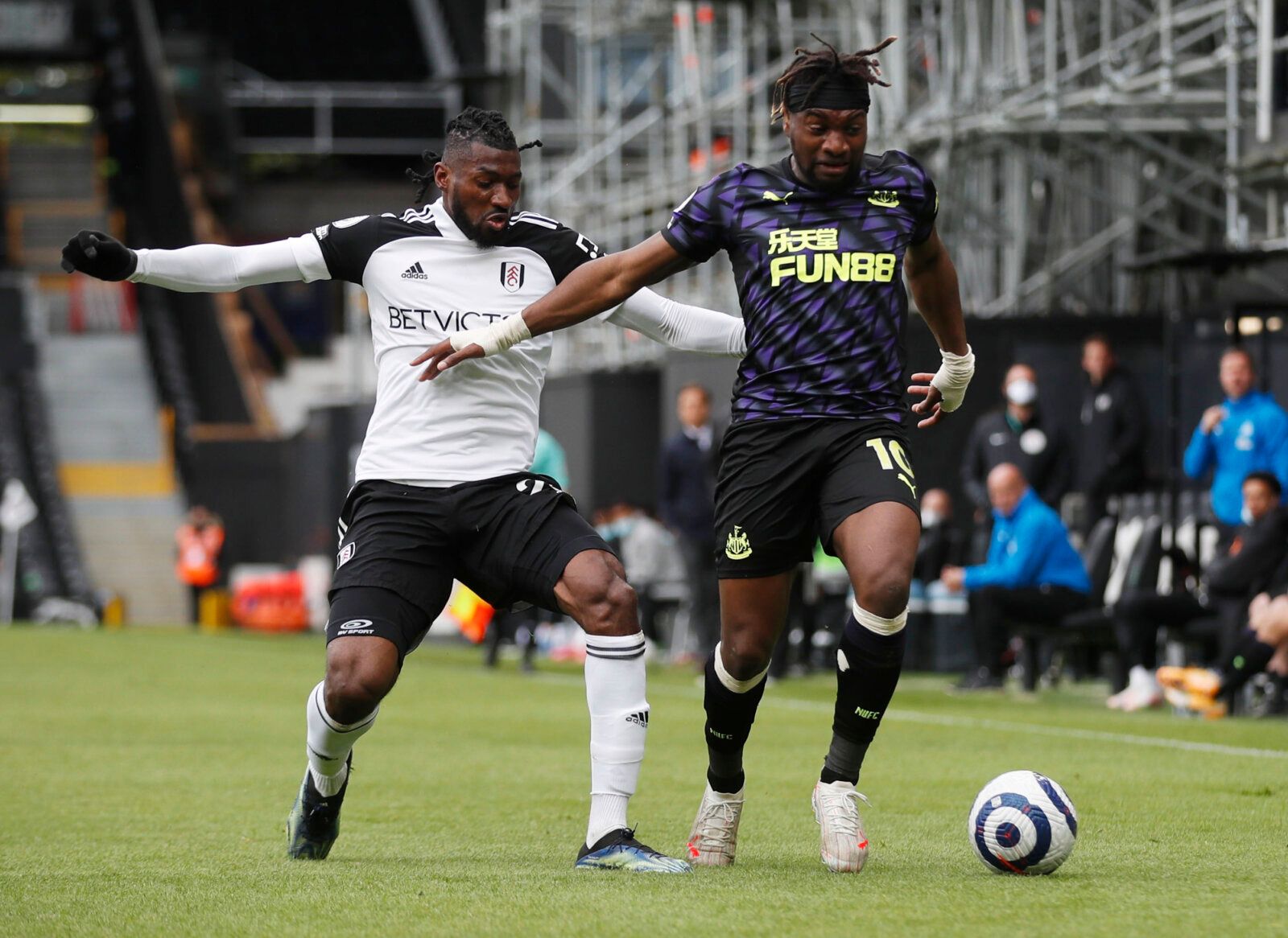 Soccer Football - Premier League - Fulham v Newcastle United - Craven Cottage, London, Britain - May 23, 2021 Fulham's Andre-Frank Zambo Anguissa in action with Newcastle United's Allan Saint-Maximin Pool via REUTERS/Matthew Childs EDITORIAL USE ONLY. No use with unauthorized audio, video, data, fixture lists, club/league logos or 'live' services. Online in-match use limited to 75 images, no video emulation. No use in betting, games or single club /league/player publications.  Please contact you