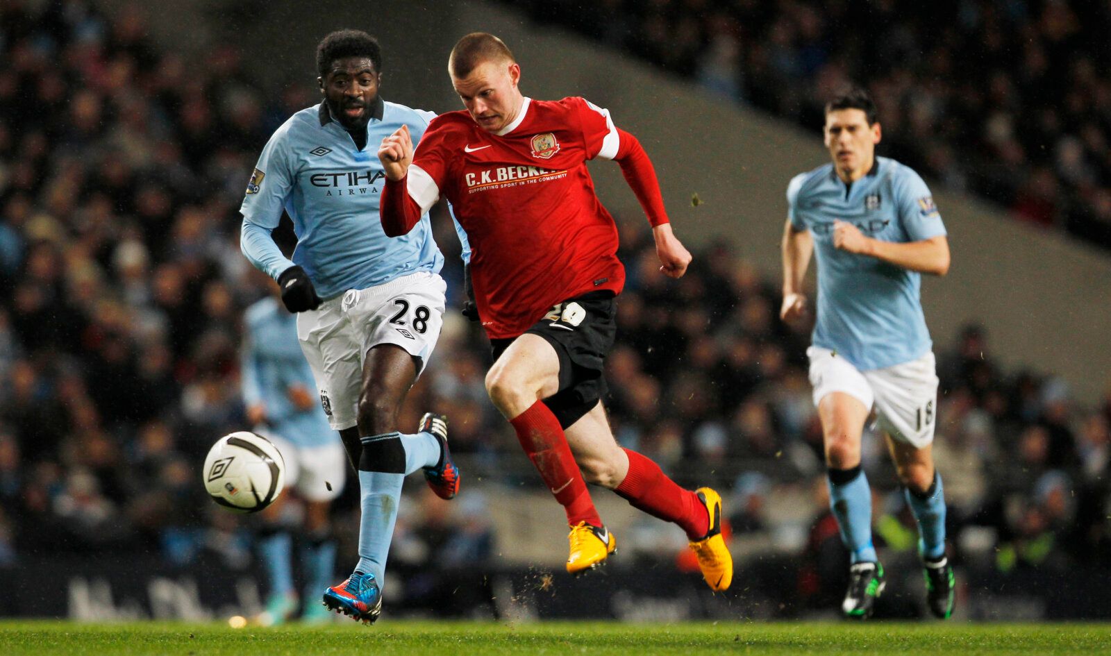 Football - Manchester City v Barnsley - FA Cup Quarter Final - Etihad Stadium - 9/3/13 
 Barnsley's Ryan Tunnicliffe (C) in action with Manchester City's Kolo Toure 
Mandatory Credit: Action Images / Craig Brough 
Livepic