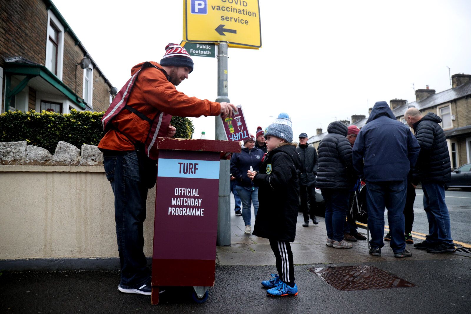 Soccer Football - Premier League - Burnley v Norwich City - Turf Moor, Burnley, Britain - October 2, 2021  Burnley fan buys a match day programme outside the stadium before the match Action Images via Reuters/Molly Darlington EDITORIAL USE ONLY. No use with unauthorized audio, video, data, fixture lists, club/league logos or 'live' services. Online in-match use limited to 75 images, no video emulation. No use in betting, games or single club /league/player publications.  Please contact your acco
