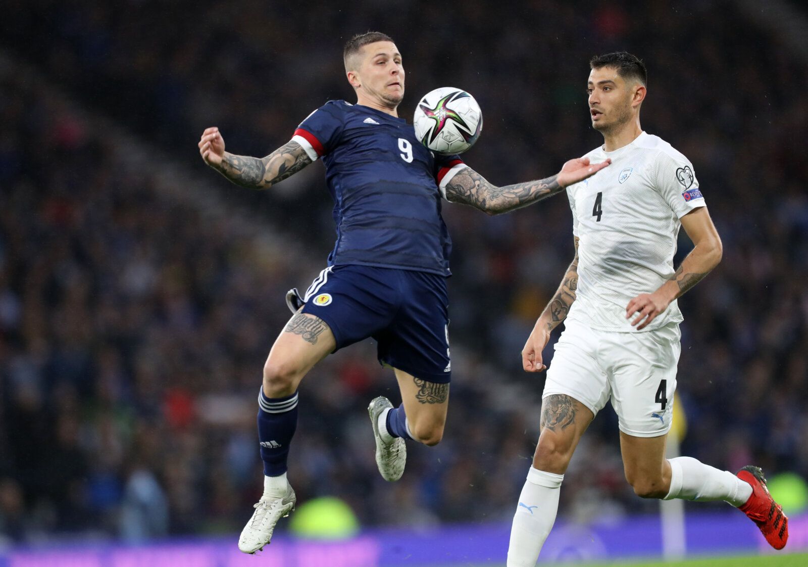 Soccer Football - World Cup - UEFA Qualifiers - Group F - Scotland v Israel - Hampden Park, Glasgow, Scotland, Britain - October 9, 2021  Scotland's Lyndon Dykes in action with Israel's Nir Bitton REUTERS/Russell Cheyne