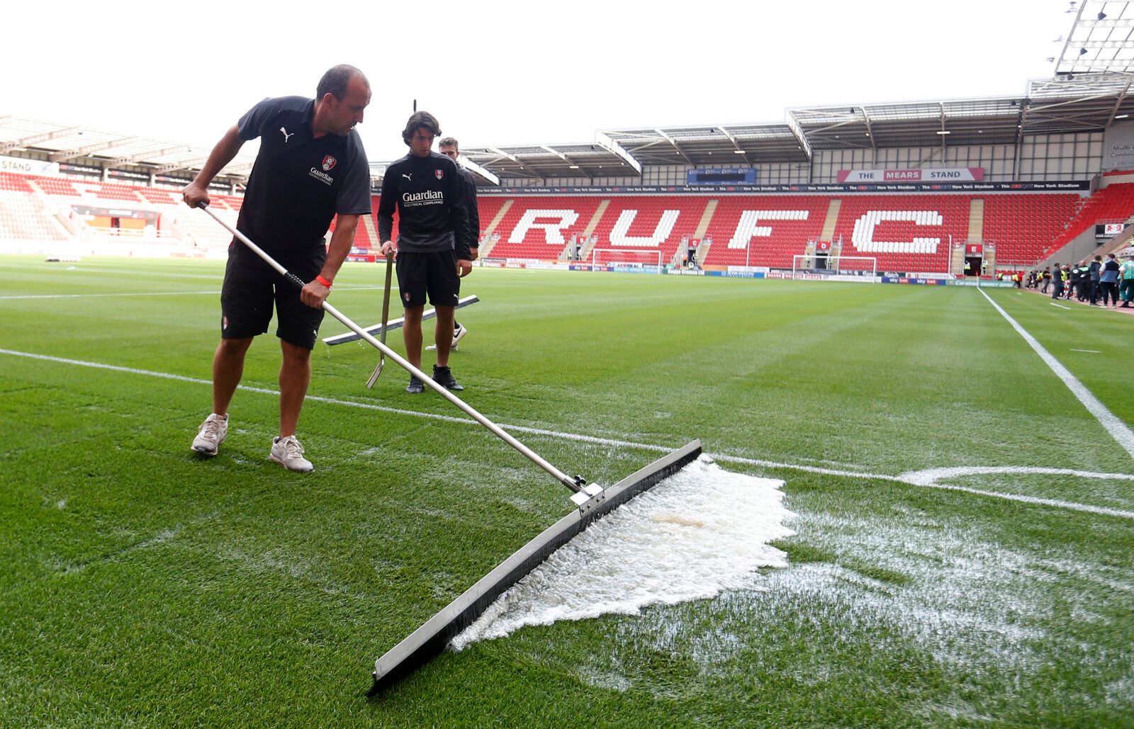 Soccer Football - Pre Season Friendly - Rotherham United v Newcastle United - AESSEAL New York Stadium, Rotherham, Britain - July 27, 2021 A member of groundstaff clears water from the side of the pitch before the match Action Images via Reuters/Ed Sykes