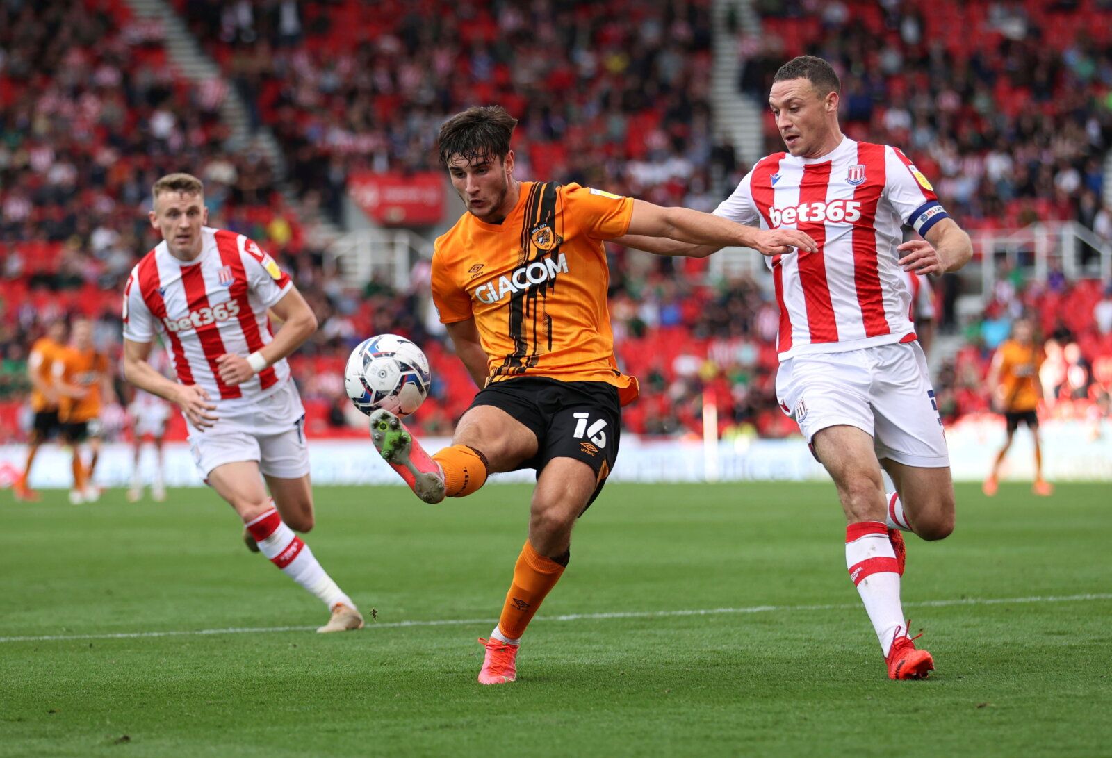 Soccer Football - England - Championship - Stoke City v Hull City - bet365 Stadium, Stoke-on-Trent, Britain - September 25, 2021  Hull City's Ryan Longman in action with Stoke City's James Chester  Action Images/John Clifton   EDITORIAL USE ONLY. No use with unauthorized audio, video, data, fixture lists, club/league logos or 