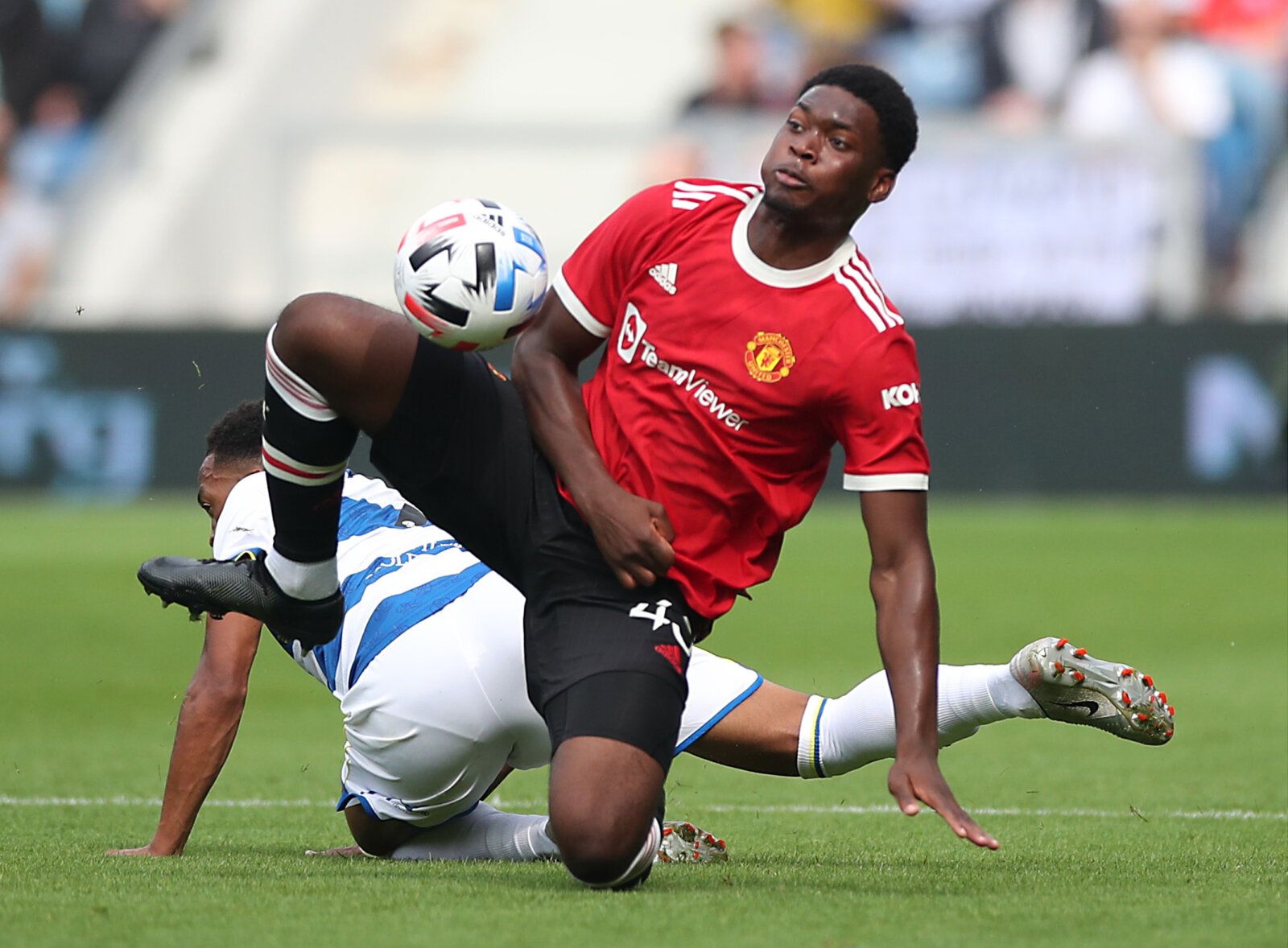 Soccer Football - Pre Season Friendly - Queens Park Rangers v Manchester United - Loftus Road. London, Britain - July 24, 2021 Manchester United's Teden Mengi in action with Queens Park Rangers' Chris Willock Action Images via Reuters/Peter Cziborra