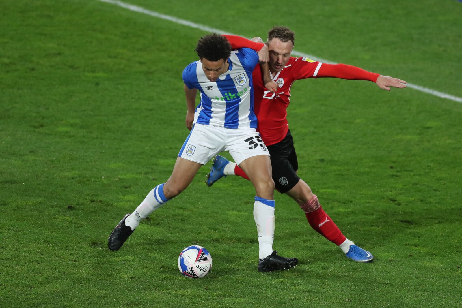 Soccer Football - Championship - Huddersfield Town v Barnsley - John Smith's Stadium, Huddersfield, Britain - April 21, 2021 Barnsley's Cauley Woodrow in action with Huddersfield Town's Rarmani Edmonds-Green Action Images/Lee Smith EDITORIAL USE ONLY. No use with unauthorized audio, video, data, fixture lists, club/league logos or 'live' services. Online in-match use limited to 75 images, no video emulation. No use in betting, games or single club /league/player publications.  Please contact you