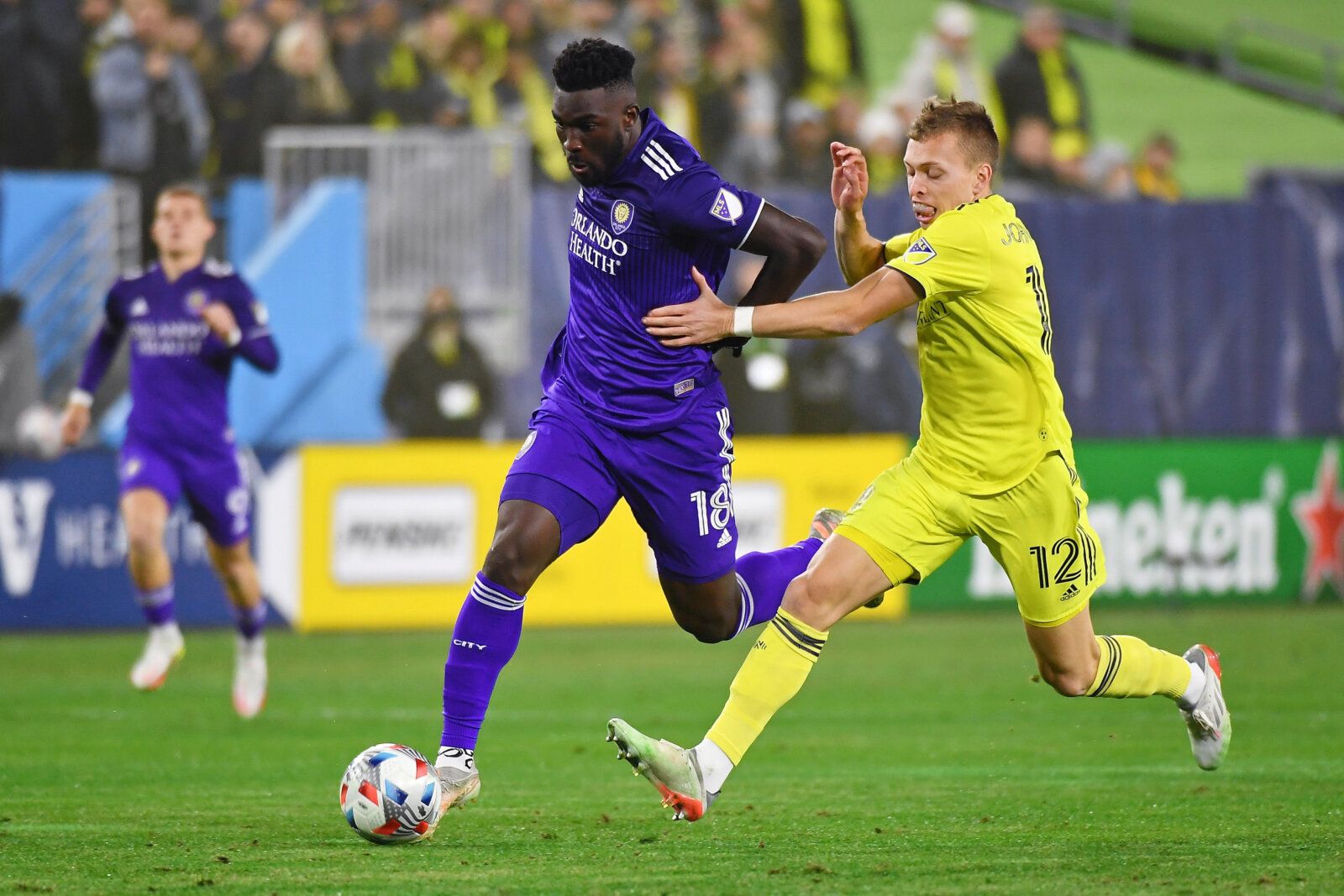 Nov 23, 2021; Nashville, TN, USA; Orlando City forward Daryl Dike (18) dribbles the ball past Nashville SC defender Alistair Johnston (12) during the first half of a round one MLS Playoff game at Nissan Stadium. Mandatory Credit: Christopher Hanewinckel-USA TODAY Sports