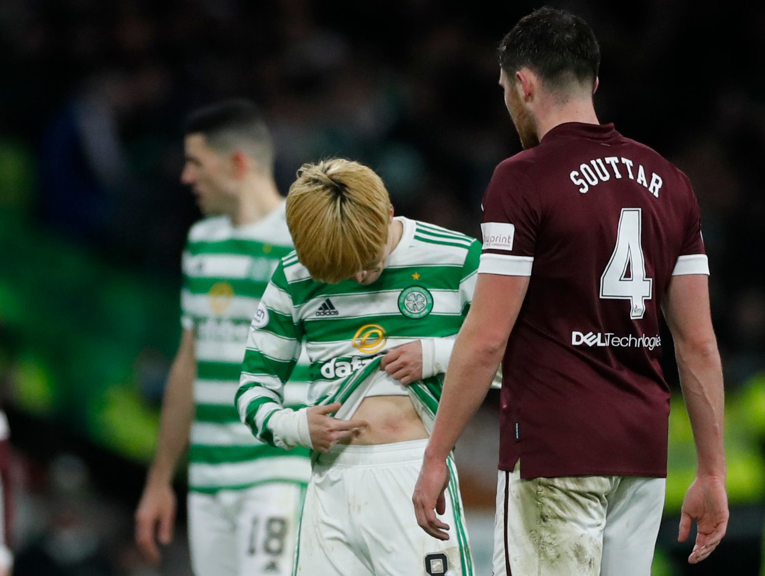 Soccer Football - Scottish Premiership - Celtic v Heart of Midlothian - Celtic Park, Glasgow, Scotland, Britain - December 2, 2021 Celtic's Kyogo Furuhashi looks at his stomach after clashing with Heart of Midlothian's John Souttar Action Images via Reuters/Lee Smith
