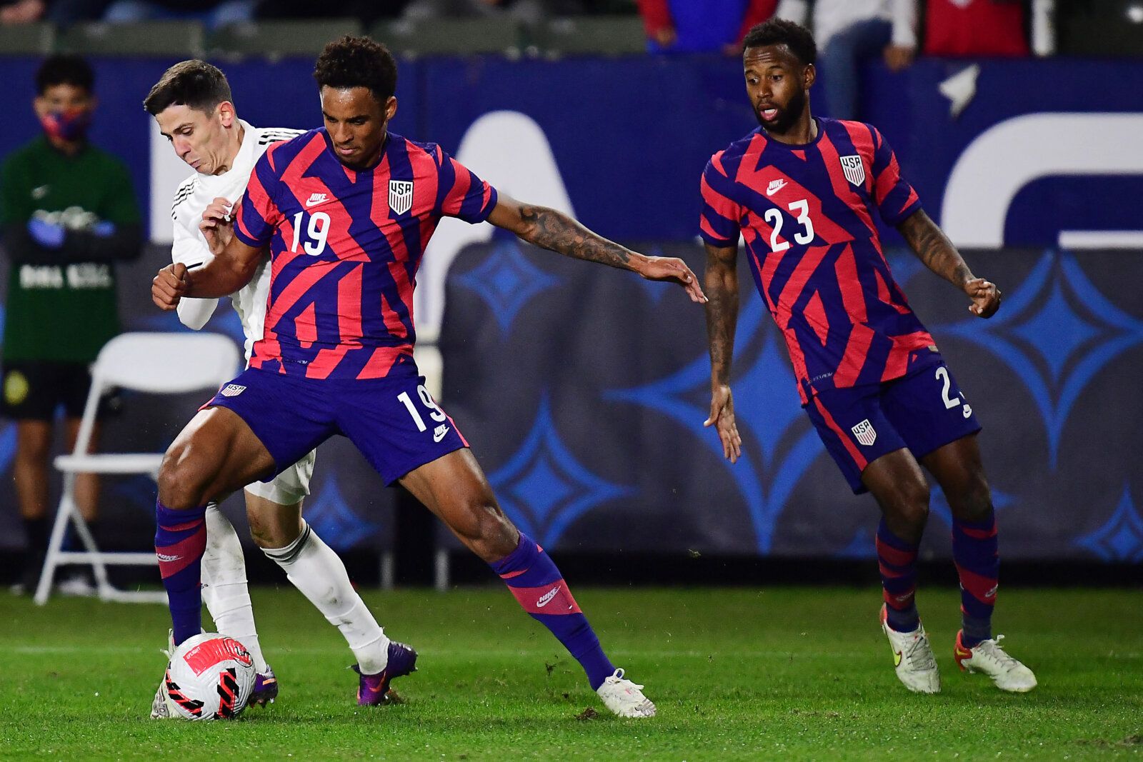 Dec 18, 2021; Carson, California, USA; USA defender Bryan Reynolds (19) and forward Taylor Booth (23) play for the ball against Bosnia &amp; Herzegovina during an International Friendly Soccer match in the second half at Dignity Health Sports Park. Mandatory Credit: Gary A. Vasquez-USA TODAY Sports