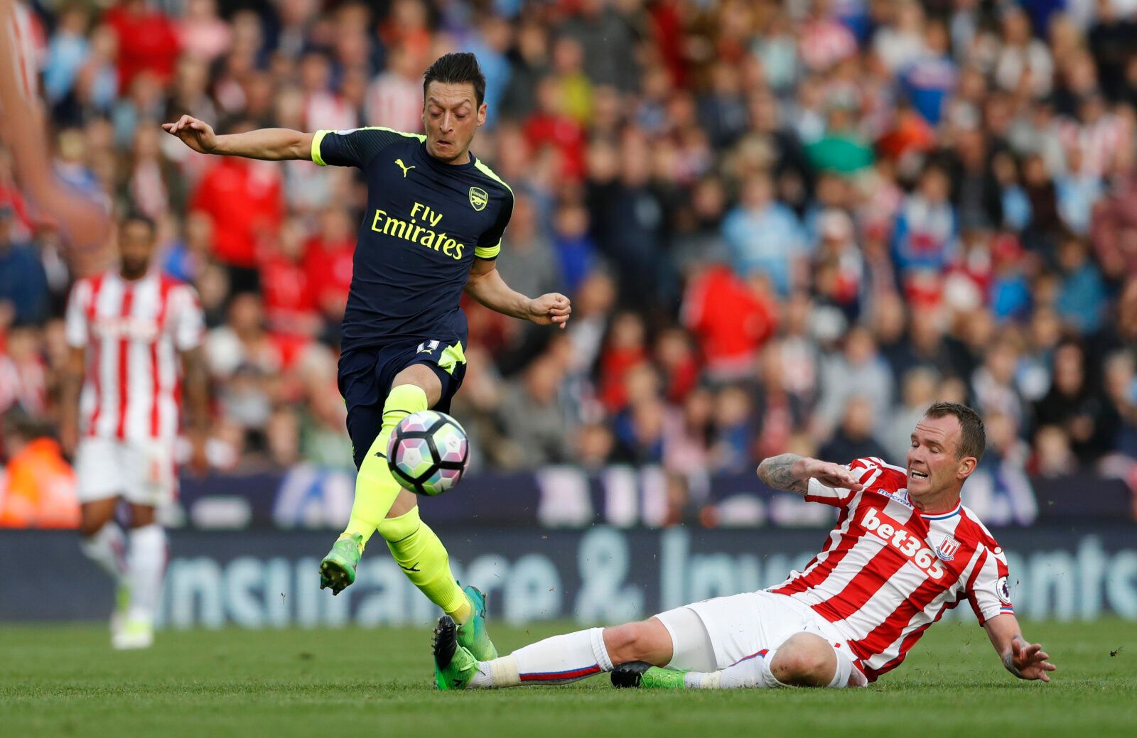 Britain Football Soccer - Stoke City v Arsenal - Premier League - bet365 Stadium - 13/5/17 Arsenal's Mesut Ozil in action with Stoke City's Glenn Whelan Action Images via Reuters / Carl Recine Livepic EDITORIAL USE ONLY. No use with unauthorized audio, video, data, fixture lists, club/league logos or 