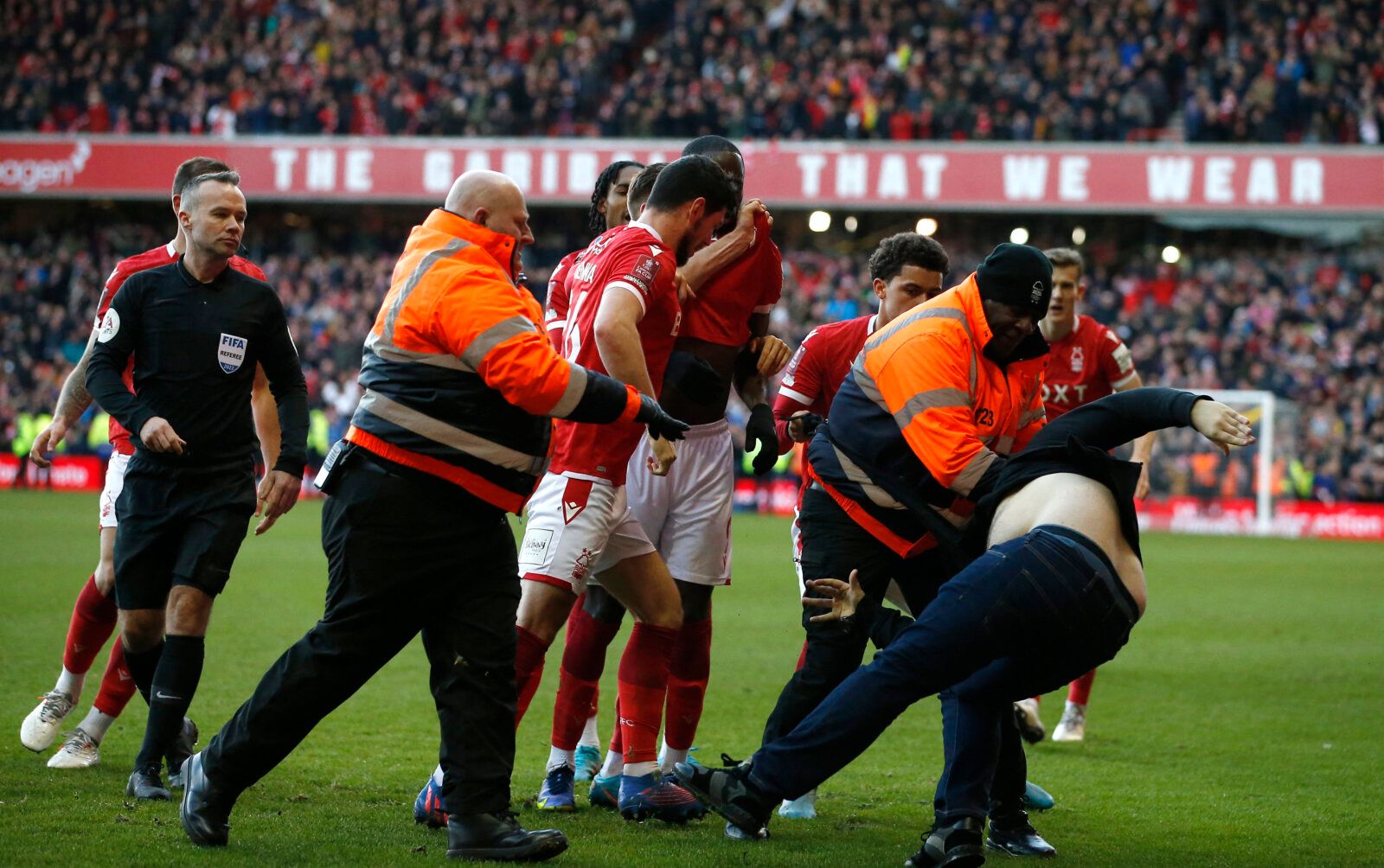 Soccer Football - FA Cup - Fourth Round - Nottingham Forest v Leicester City - The City Ground, Nottingham, Britain - February 6, 2022 A Leicester City fan is detained by stewards after invading the pitch REUTERS/Craig Brough