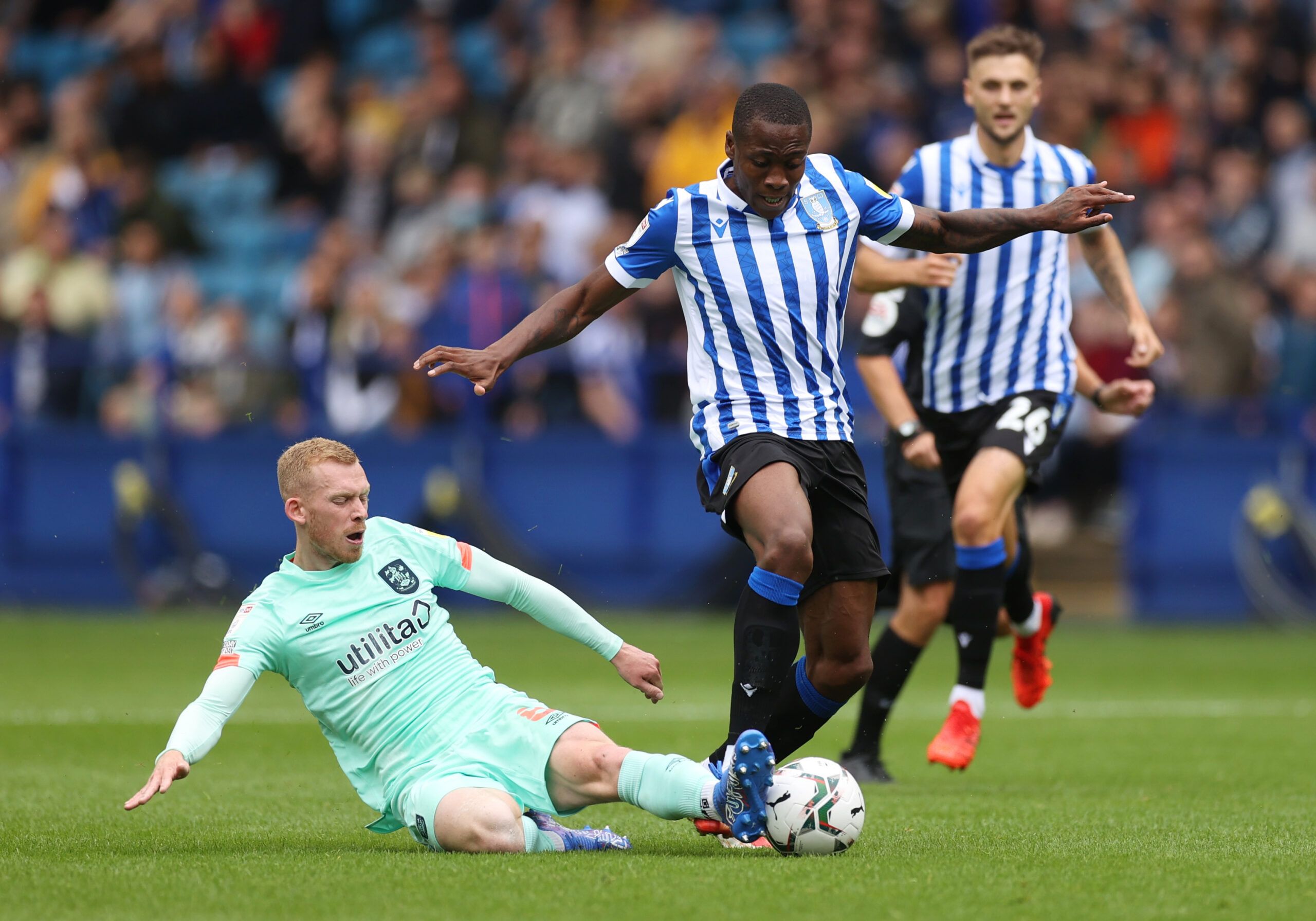 Soccer Football - Carabao Cup First Round - Sheffield Wednesday v Huddersfield Town - Hillsborough, Sheffield, Britain - August 1, 2021 Huddersfield Town's Lewis O'Brien in action with Sheffield Wednesday's Dennis Adeniran Action Images/Lee Smith