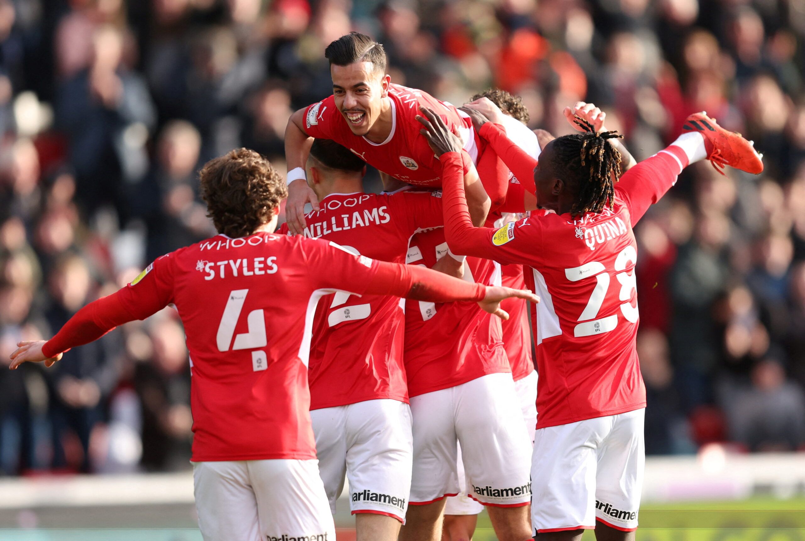 Soccer Football -  Championship - Barnsley v Middlesbrough - Oakwell, Barnsley, Britain - February 26, 2022 Barnsley's Amine Bassi celebrates scoring their second goal with teammates    Action Images/John Clifton  EDITORIAL USE ONLY. No use with unauthorized audio, video, data, fixture lists, club/league logos or 