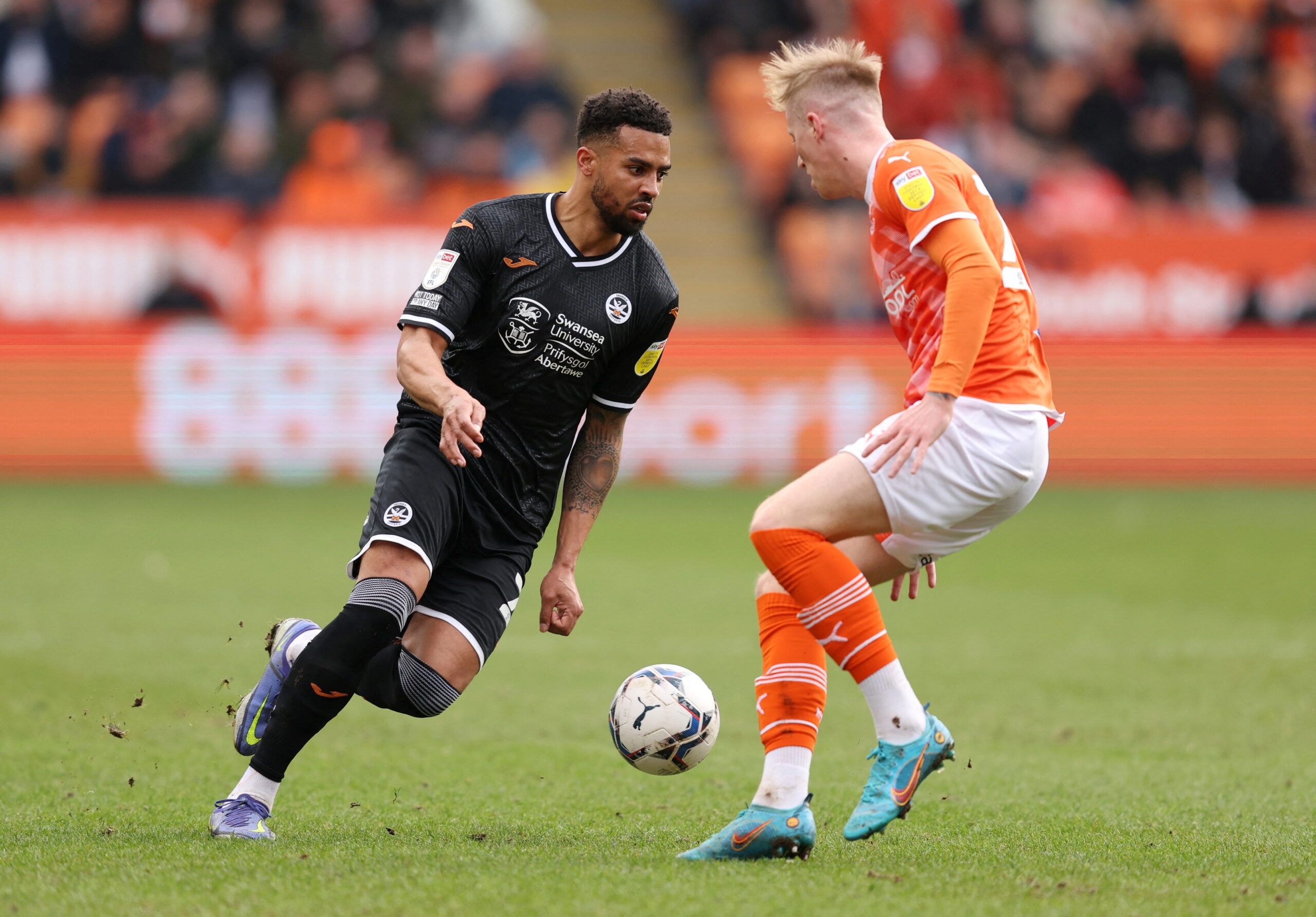 Soccer Football - Championship - Blackpool v Swansea City - Bloomfield Road, Blackpool , Britain - March 12, 2022  Swansea City's Cyrus Christie in action with Blackpool's Charlie Kirk  Action Images/John Clifton  EDITORIAL USE ONLY. No use with unauthorized audio, video, data, fixture lists, club/league logos or 