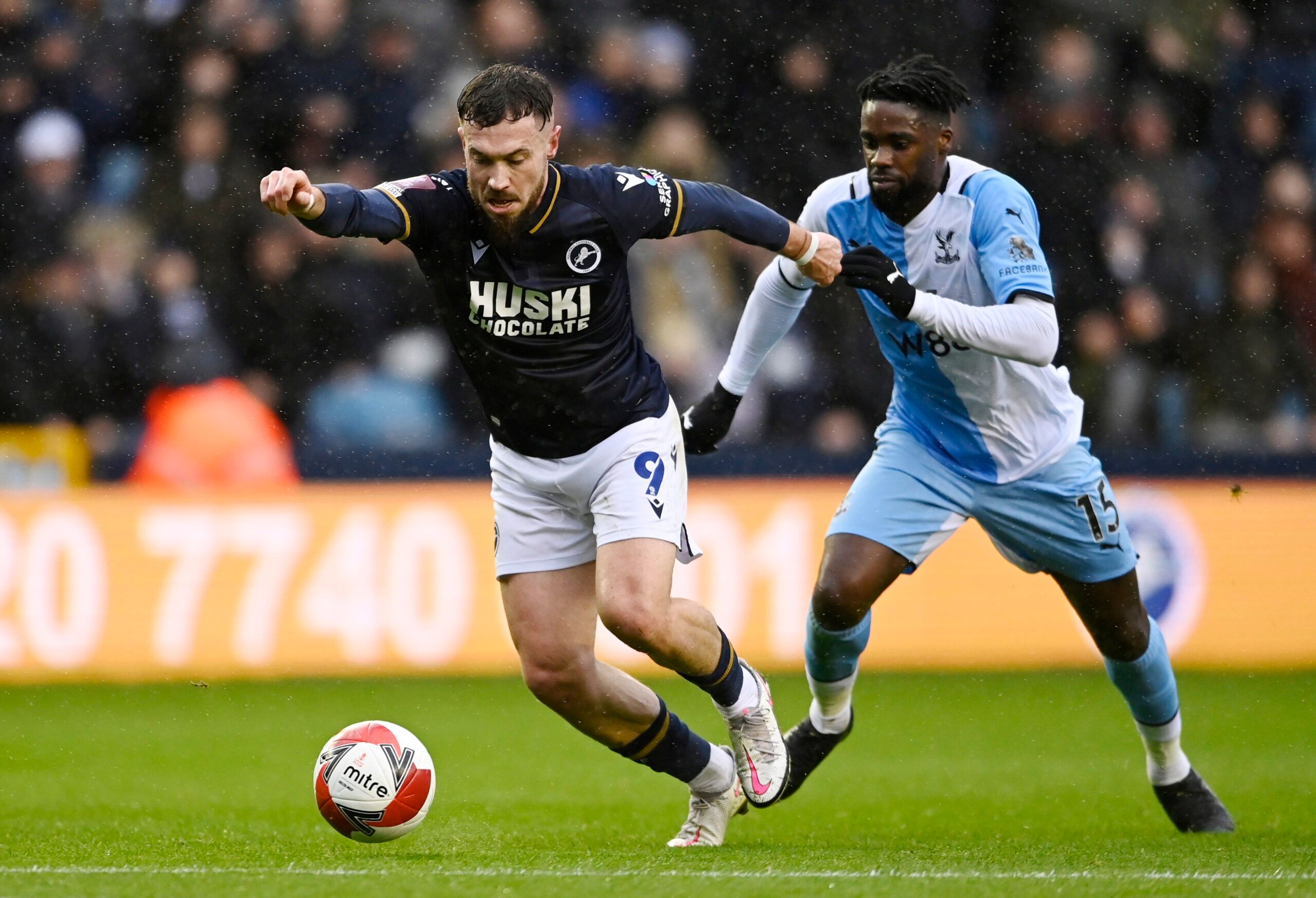 Soccer Football - FA Cup Third Round - Millwall v Crystal Palace - The Den, London, Britain - January 8, 2022 Millwall's Tom Bradshaw in action with Crystal Palace's Jeffrey Schlupp REUTERS/Tony Obrien