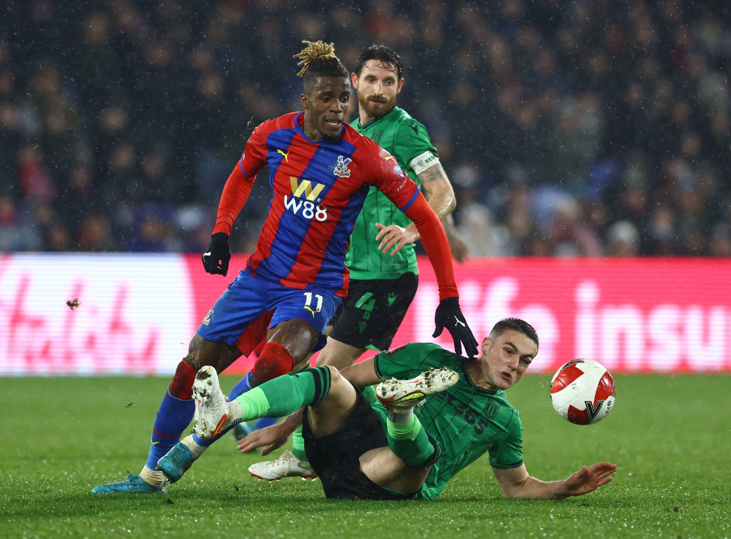 Soccer Football - FA Cup Fifth Round - Crystal Palace v Stoke City - Selhurst Park, London, Britain - March 1, 2022 Crystal Palace's Wilfried Zaha in action with Stoke City's Taylor Harwood-Bellis REUTERS/David Klein