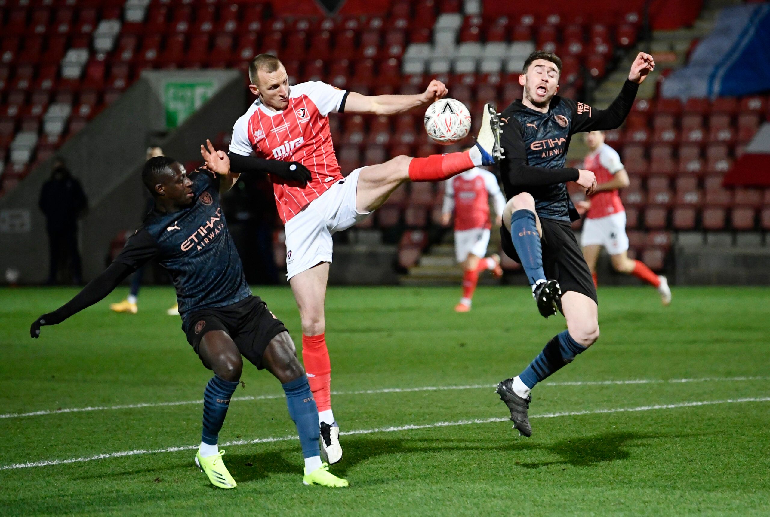 Soccer Football - FA Cup - Fourth Round - Cheltenham Town v Manchester City - The Jonny-Rocks Stadium, Cheltenham, Britain - January 23, 2021 Cheltenham Town's William Boyle in action with Manchester City's Aymeric Laporte and Benjamin Mendy Pool via REUTERS/Toby Melville