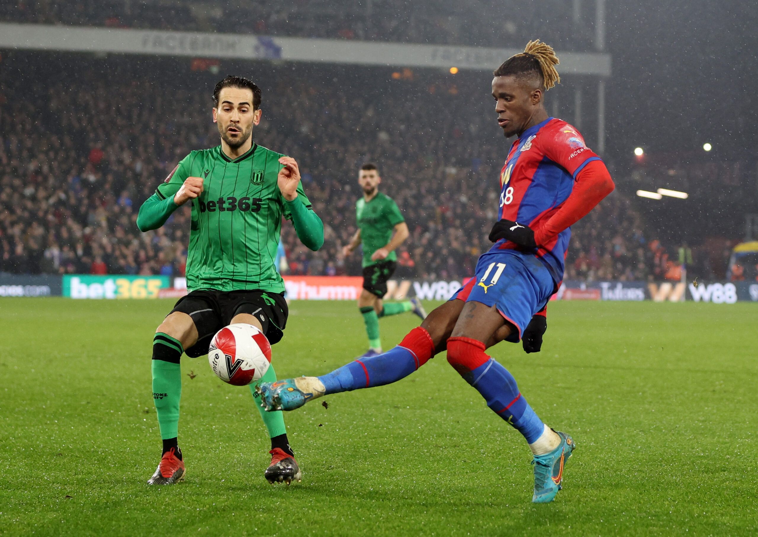 Soccer Football - FA Cup Fifth Round - Crystal Palace v Stoke City - Selhurst Park, London, Britain - March 1, 2022 Crystal Palace's Wilfried Zaha in action with Stoke City's Mario Vrancic Action Images via Reuters/Paul Childs