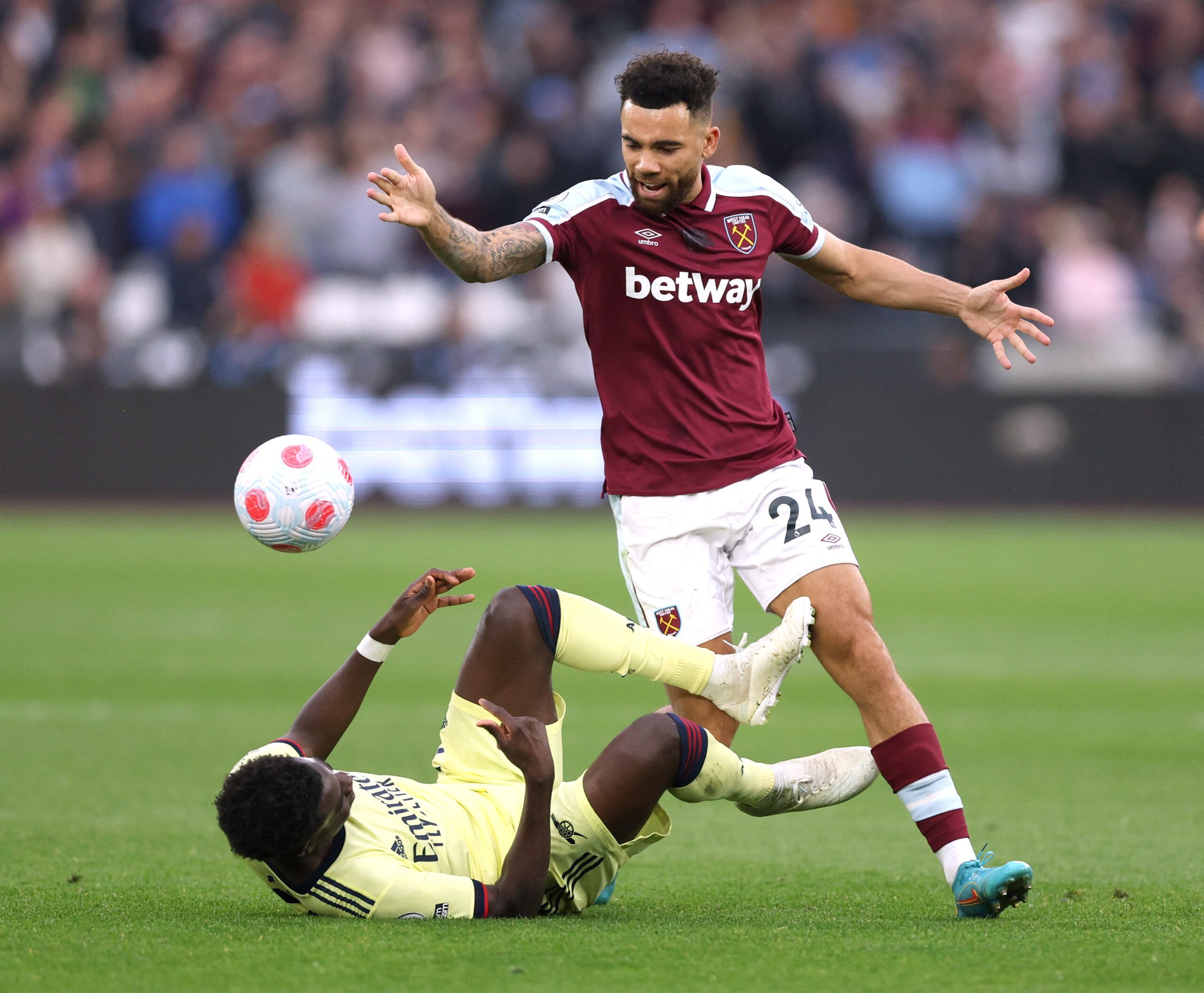 Soccer Football - Premier League - West Ham United v Arsenal - London Stadium, London, Britain - May 1, 2022 Arsenal's Bukayo Saka in action with West Ham United's Ryan Fredericks Action Images via Reuters/Matthew Childs EDITORIAL USE ONLY. No use with unauthorized audio, video, data, fixture lists, club/league logos or 'live' services. Online in-match use limited to 75 images, no video emulation. No use in betting, games or single club /league/player publications.  Please contact your account r