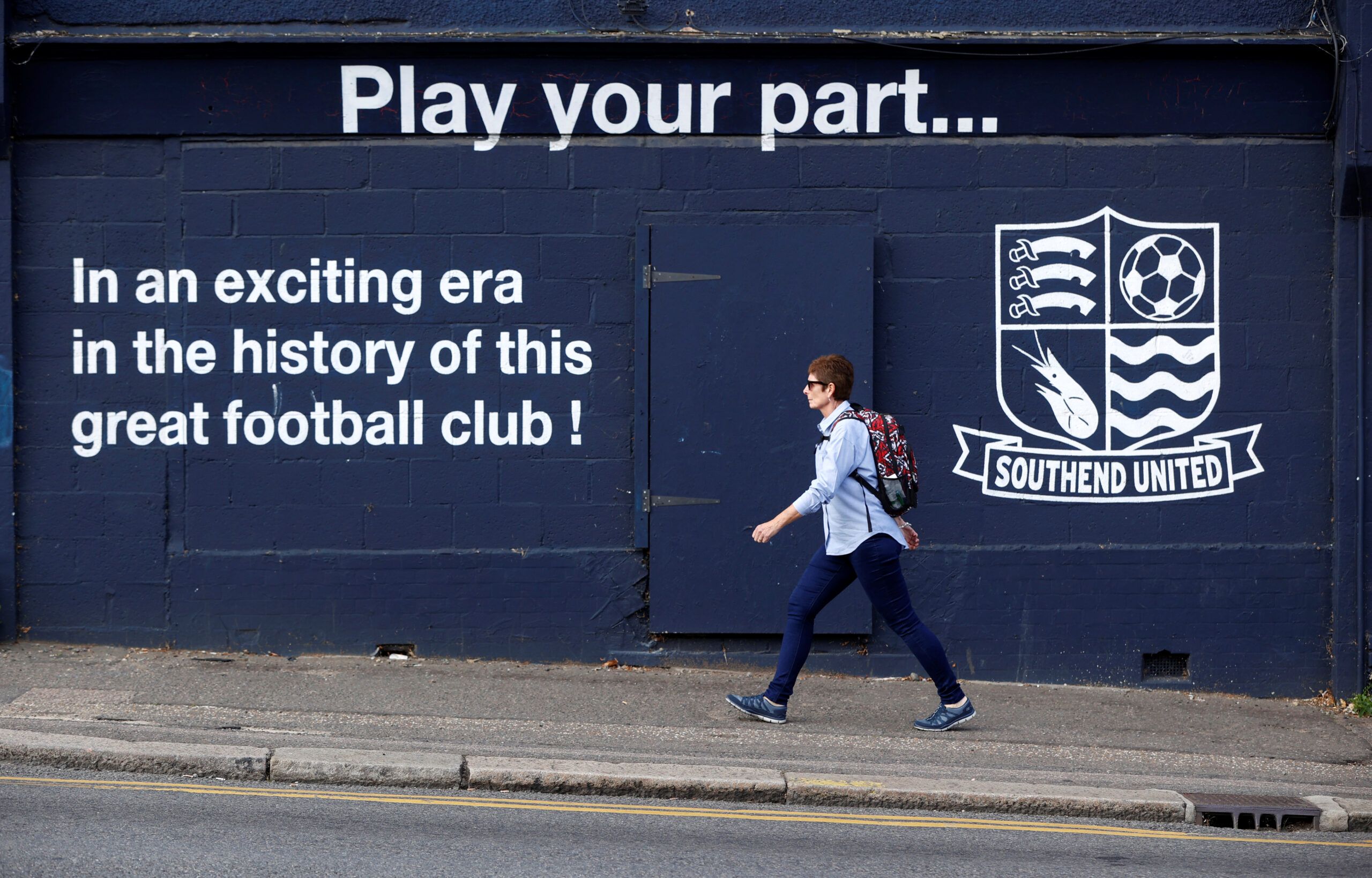 Soccer Football - General views outside Southend United - Roots Hall, Southend, Britain - September 17, 2020   A woman walks past Roots Hall stadium   REUTERS/John Sibley
