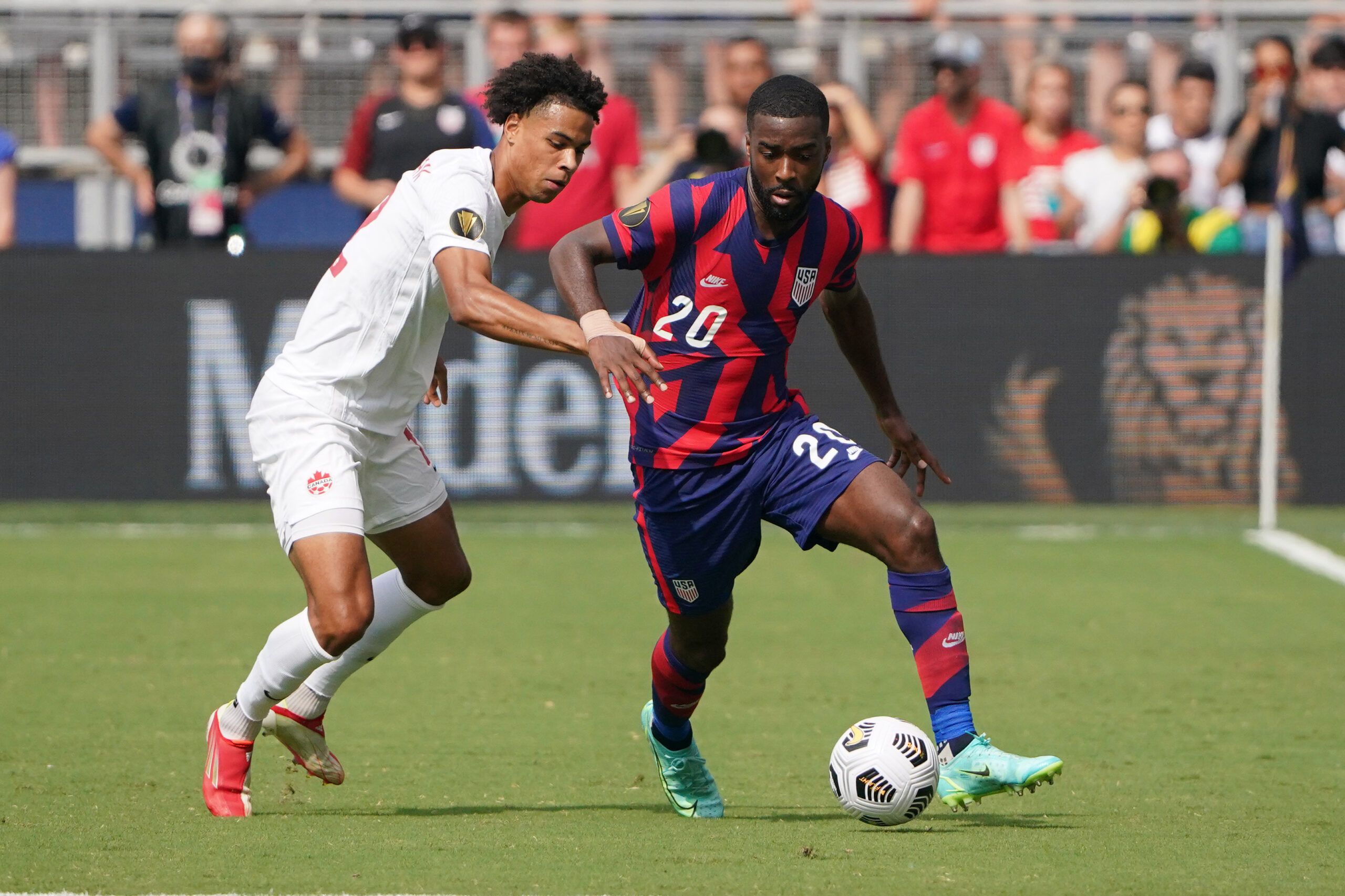 Jul 18, 2021; Kansas City, Kansas, USA; United States defender Shaq Moore (20) controls the ball as Canada forward Tajon Buchanan (12) defends during the CONCACAF Gold Cup Soccer group stage play at Children's Mercy Park. Mandatory Credit: Denny Medley-USA TODAY Sports