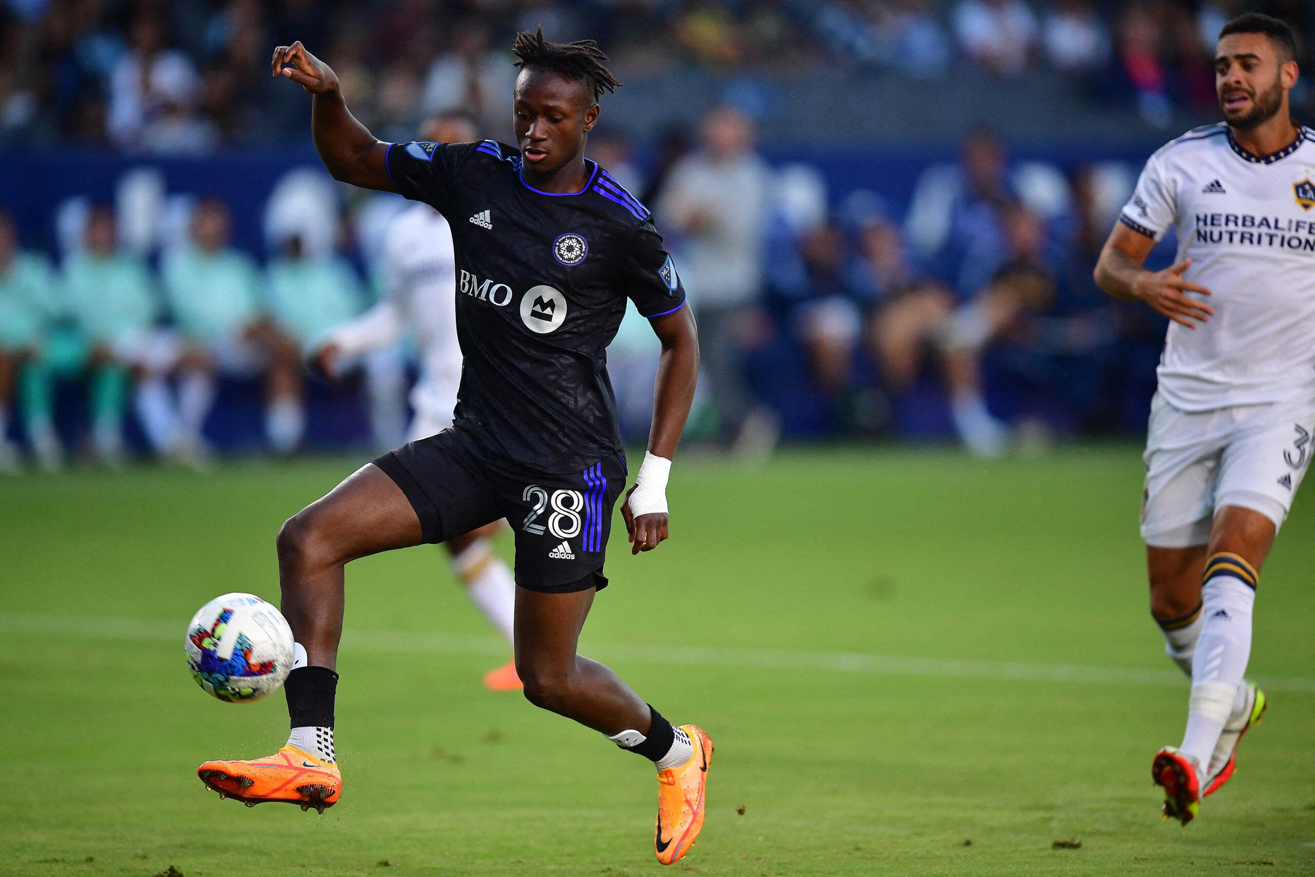 Jul 4, 2022; Carson, California, USA; CF Montrealmidfielder Ismael Kone (28) moves in for a shot on goal ahead of Los Angeles Galaxy defender Derrick Williams (3) during the first half at Dignity Health Sports Park. Mandatory Credit: Gary A. Vasquez-USA TODAY Sports