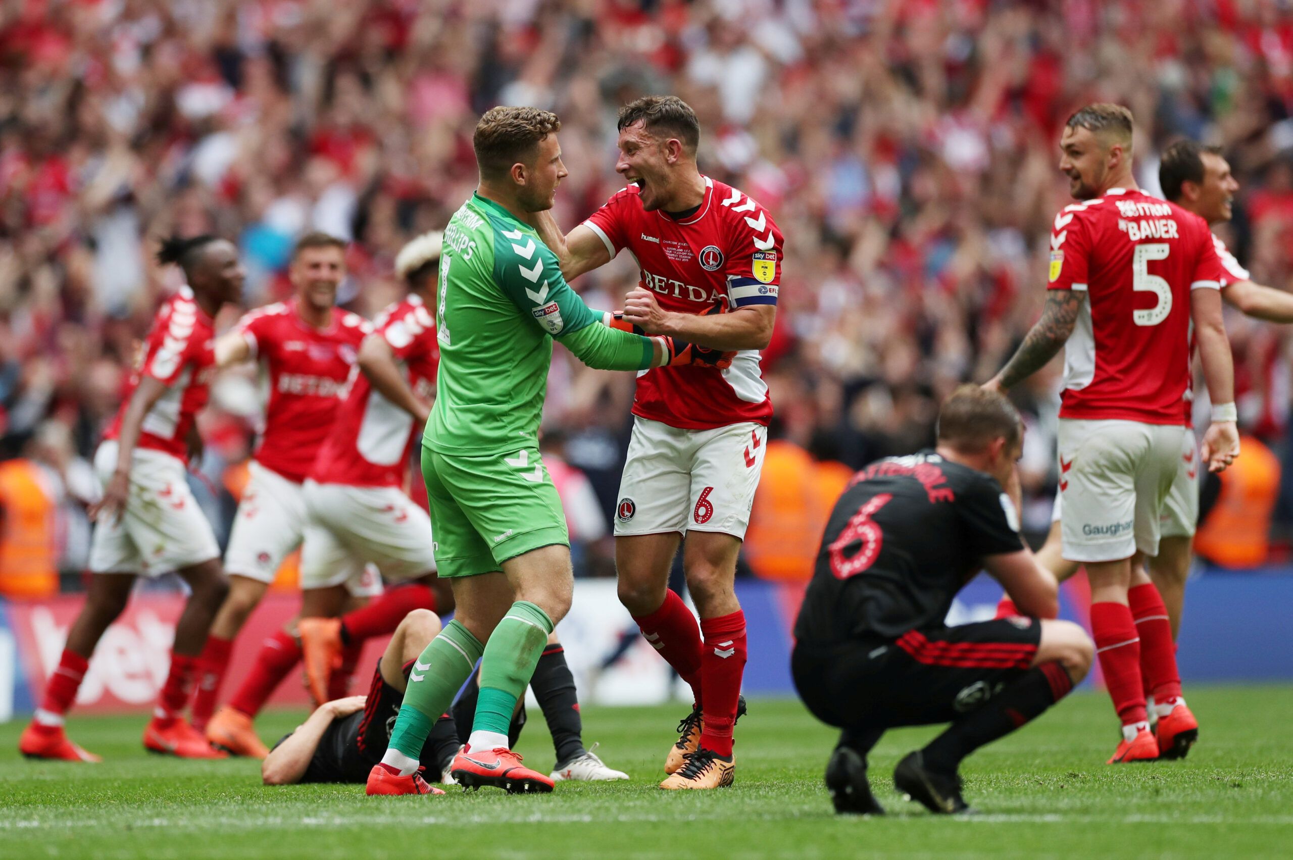 Soccer Football - League One Playoff Final - Sunderland v Charlton Athletic - Wembley Stadium, London, Britain - May 26, 2019  Charlton Athletic's Dillon Phillips and Jason Pearce celebrate after the match as Sunderland's Lee Cattermole looks dejected   Action Images/Lee Smith  EDITORIAL USE ONLY. No use with unauthorized audio, video, data, fixture lists, club/league logos or 
