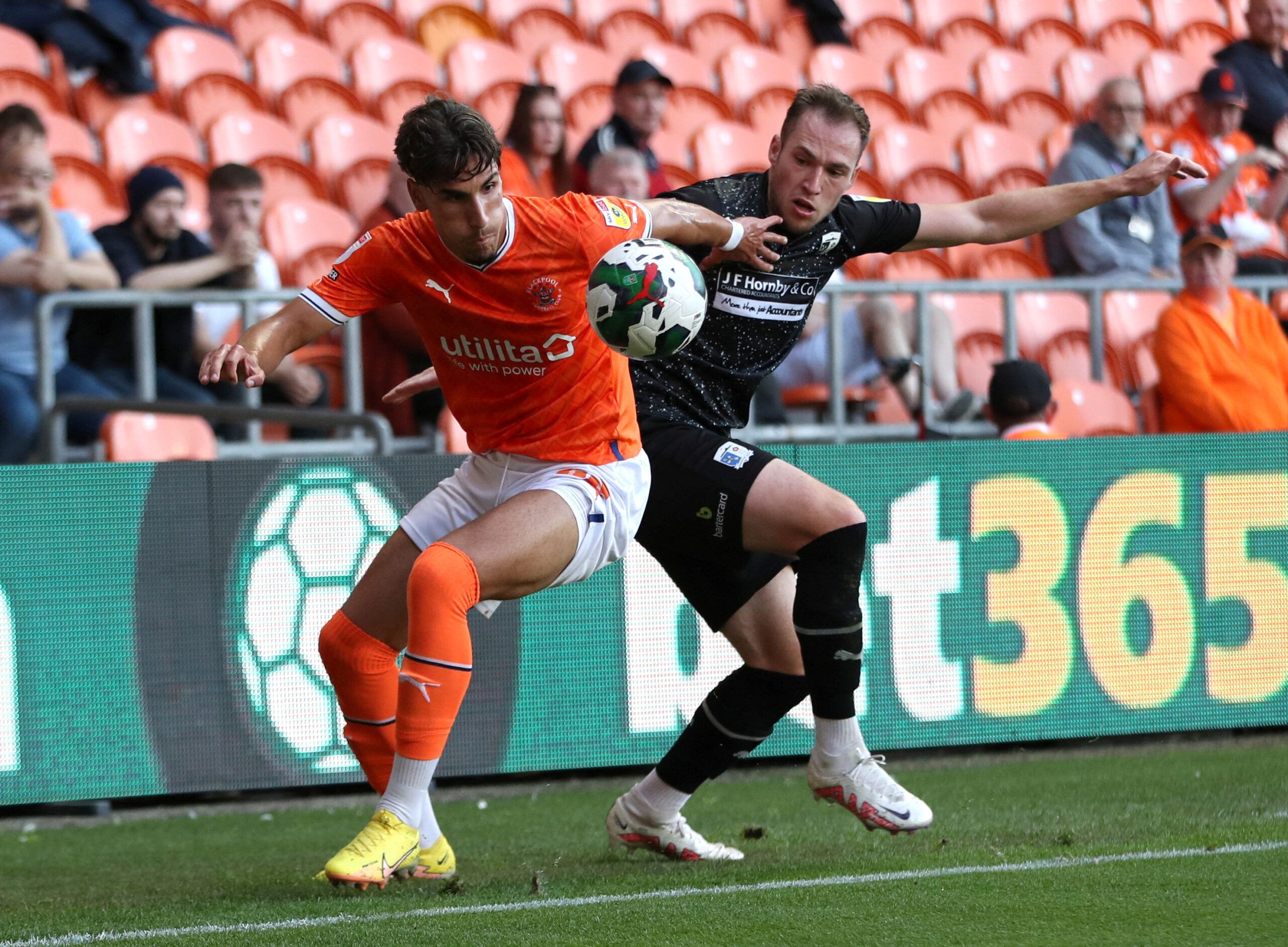 Soccer Football - Carabao Cup - Blackpool v Barrow - Bloomfield Road, Blackpool, Britain - August 9, 2022  Barrow's Josh Kay in action with Blackpool's Theo Corbeanu Action Images/Molly Darlington  EDITORIAL USE ONLY. No use with unauthorized audio, video, data, fixture lists, club/league logos or 