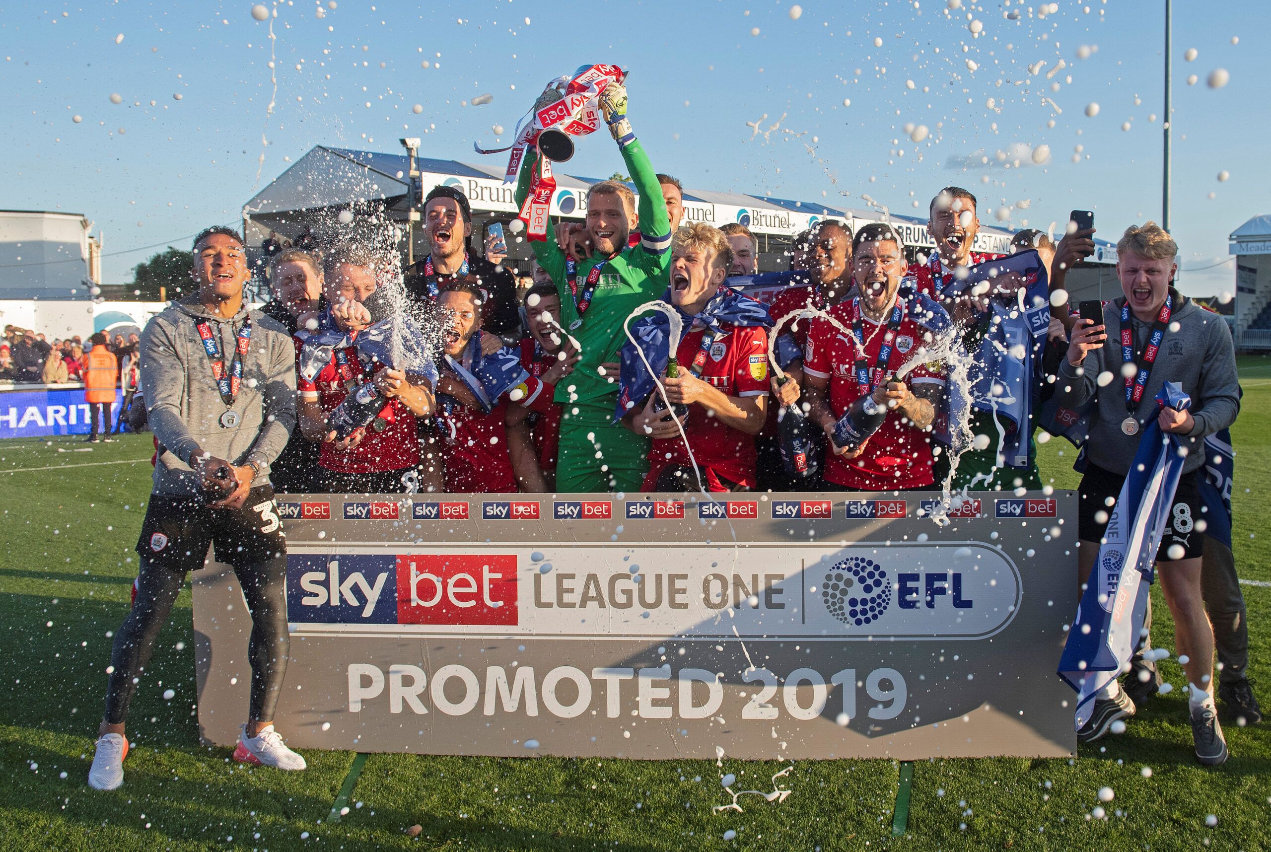 Soccer Football - League One - Bristol Rovers v Barnsley - Memorial Stadium, Bristol, Britain - May 4, 2019   Barnsley players celebrate their promotion with the trophy and spraying sparkling wine after the match    Action Images/Alan Walter    EDITORIAL USE ONLY. No use with unauthorized audio, video, data, fixture lists, club/league logos or 