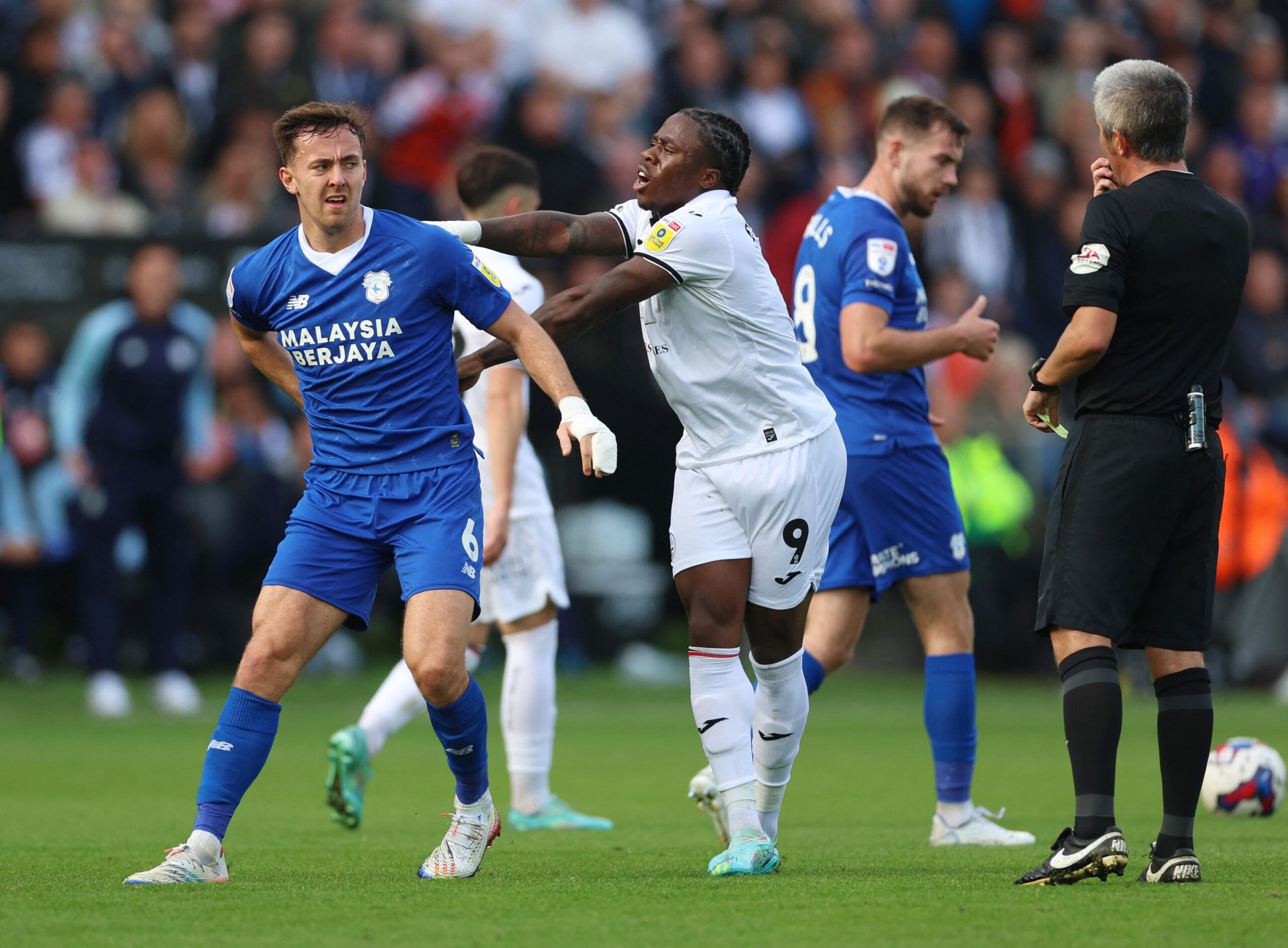 Soccer Football - Championship - Swansea City v Cardiff City - Swansea.com Stadium, Swansea, Britain - October 23, 2022 Swansea City's Michael Obafemi clashes with Cardiff City's Ryan Wintle Action Images/Matthew Childs EDITORIAL USE ONLY. No use with unauthorized audio, video, data, fixture lists, club/league logos or 'live' services. Online in-match use limited to 75 images, no video emulation. No use in betting, games or single club /league/player publications.  Please contact your account re