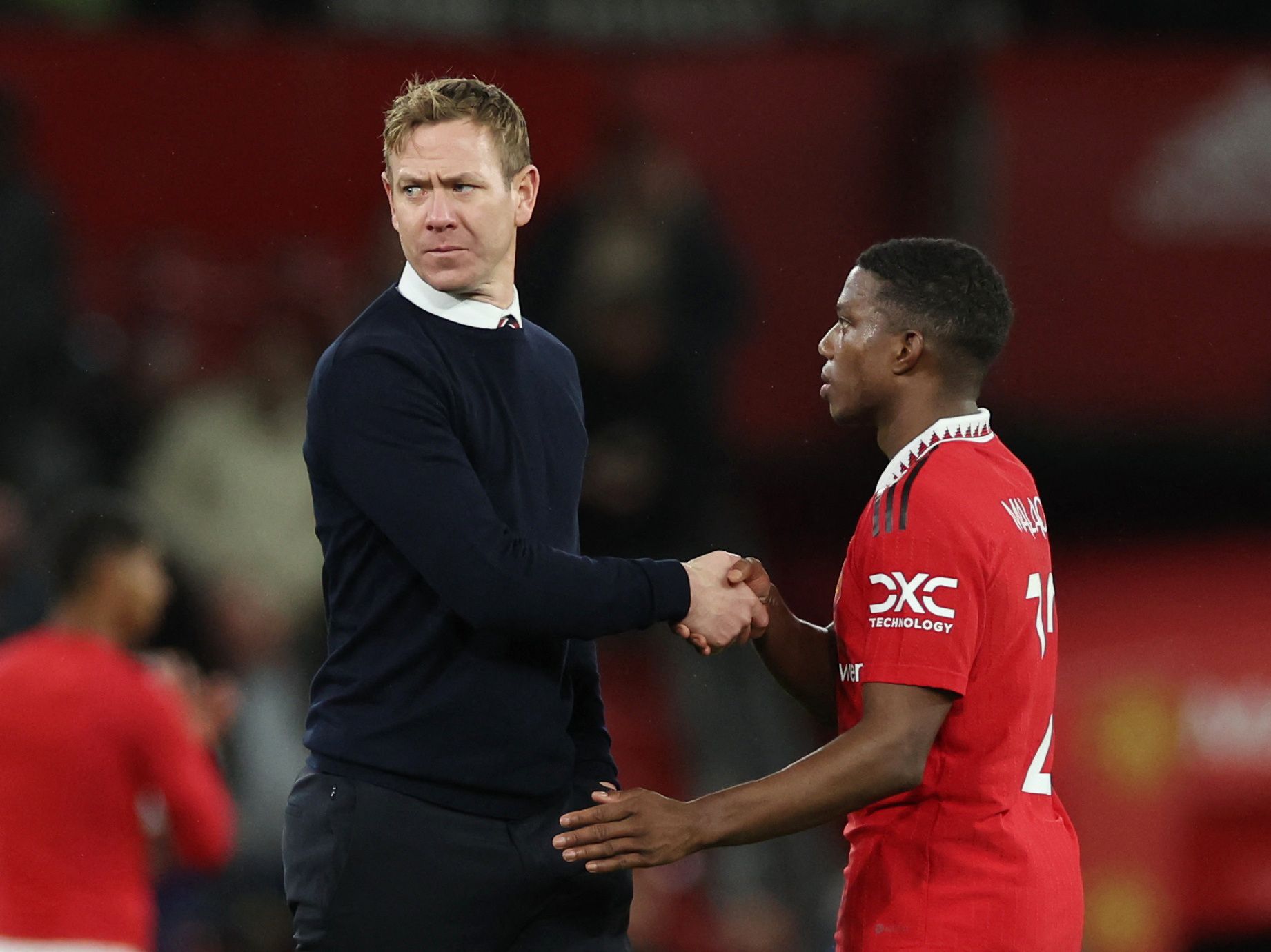 Soccer Football - Carabao Cup - Quarter Final - Manchester United v Charlton Athletic - Old Trafford, Manchester, Britain - January 10, 2023 Manchester United's Tyrell Malacia shakes hands with Charlton Athletic manager Dean Holden after the match REUTERS/Phil Noble EDITORIAL USE ONLY. No use with unauthorized audio, video, data, fixture lists, club/league logos or 'live' services. Online in-match use limited to 75 images, no video emulation. No use in betting, games or single club /league/playe