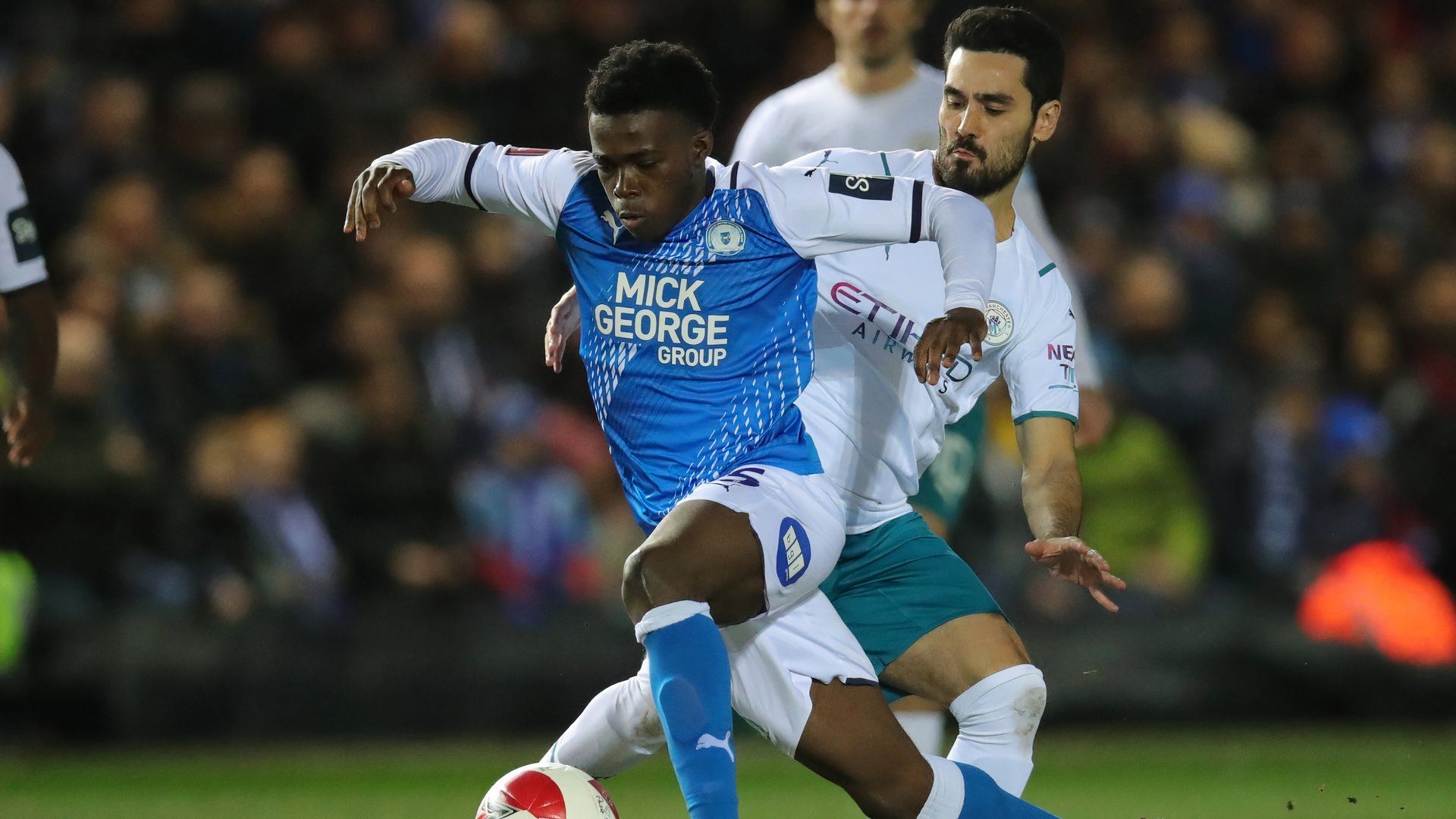 Manchester City's Ilkay Gundogan in action with Peterborough United's Kwame Poku
