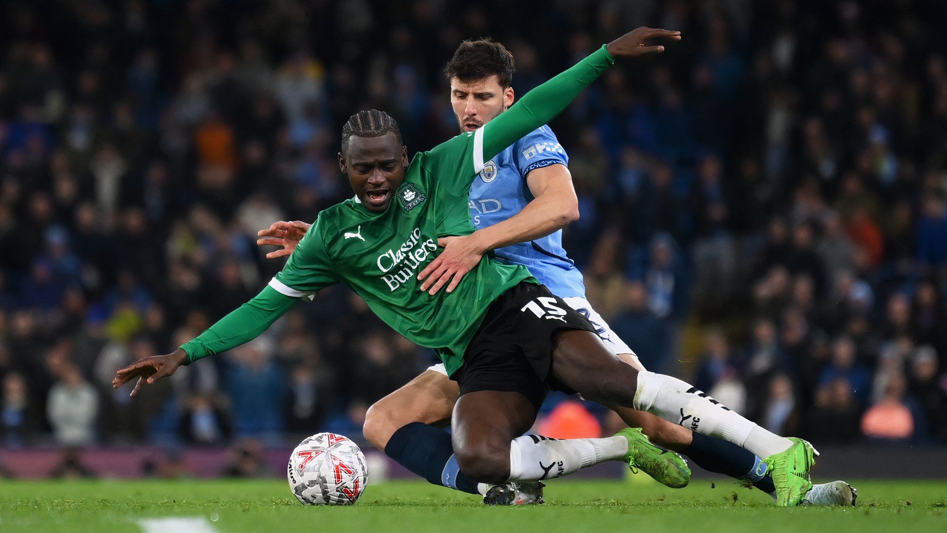 Plymouth Argyle's Mustapha Bundu in action with Manchester City's Ruben Dias